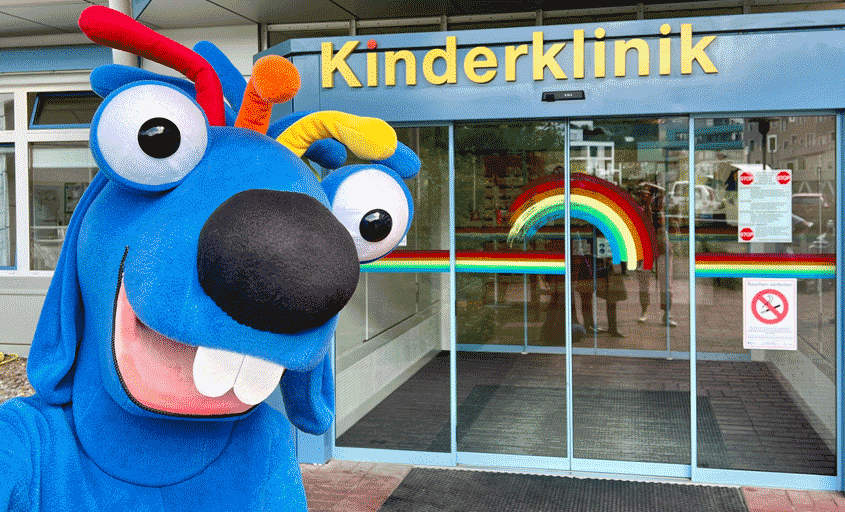 Das blaue Maskottchen vor dem Eingang der Kinderklinik
