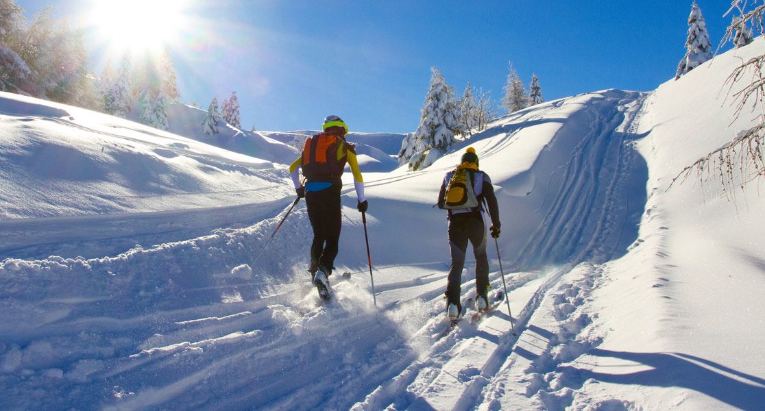 Zwei Personen gehen im Schnee Langlaufen