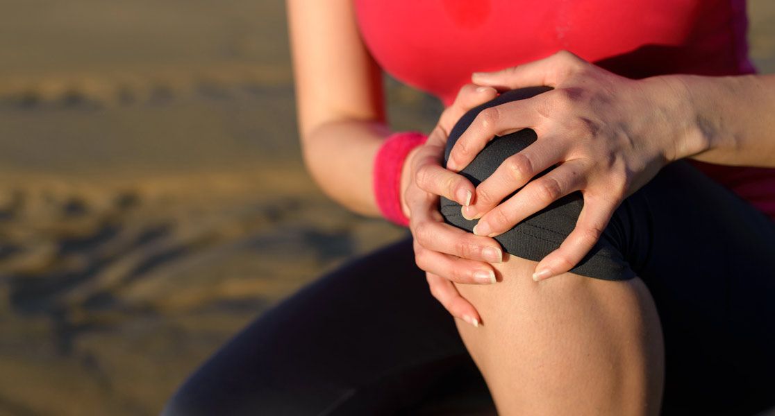 Hand fasst an ein Knie