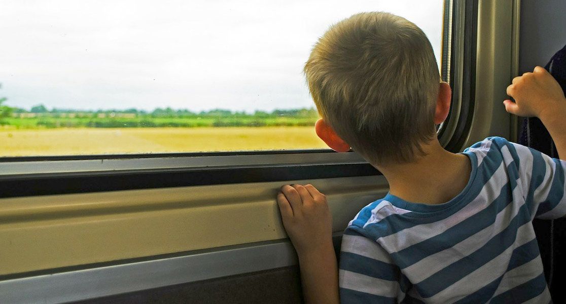 Kind schaut aus einem Zugfenster