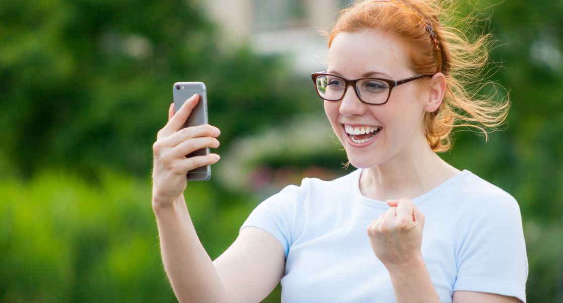 Frau mit Brille hält ein Smartphone in der Hand
