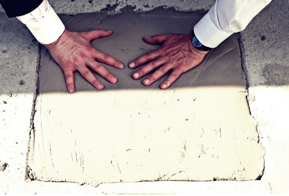Hände mache einen Abdruck im Beton