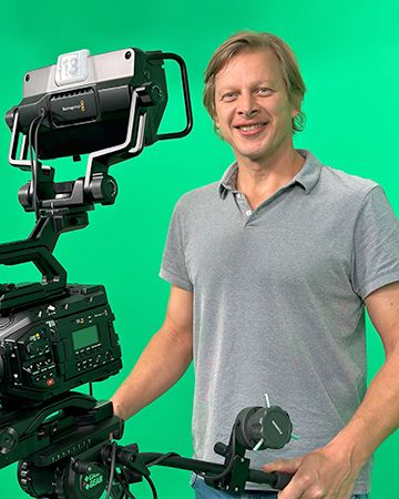 Klaus Fröhlich mit Kamera vor dem Green Screen