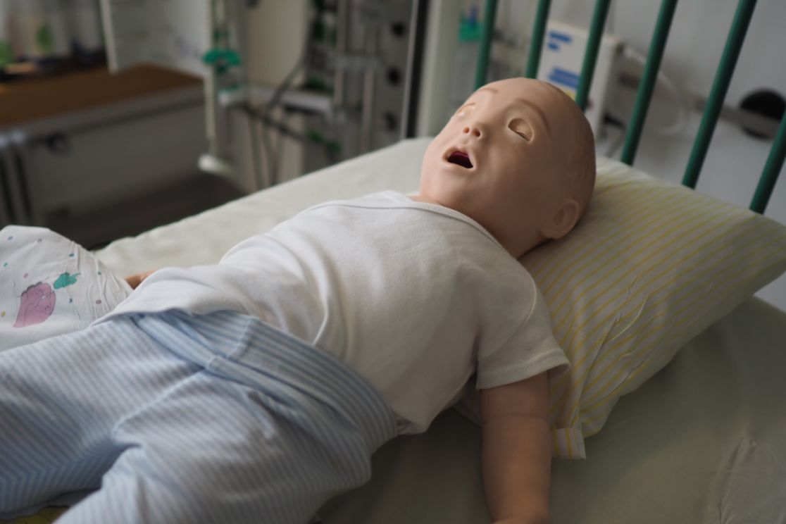 Eine Simulationspuppe zum Trainieren liegt auf einem Behandlungsbett