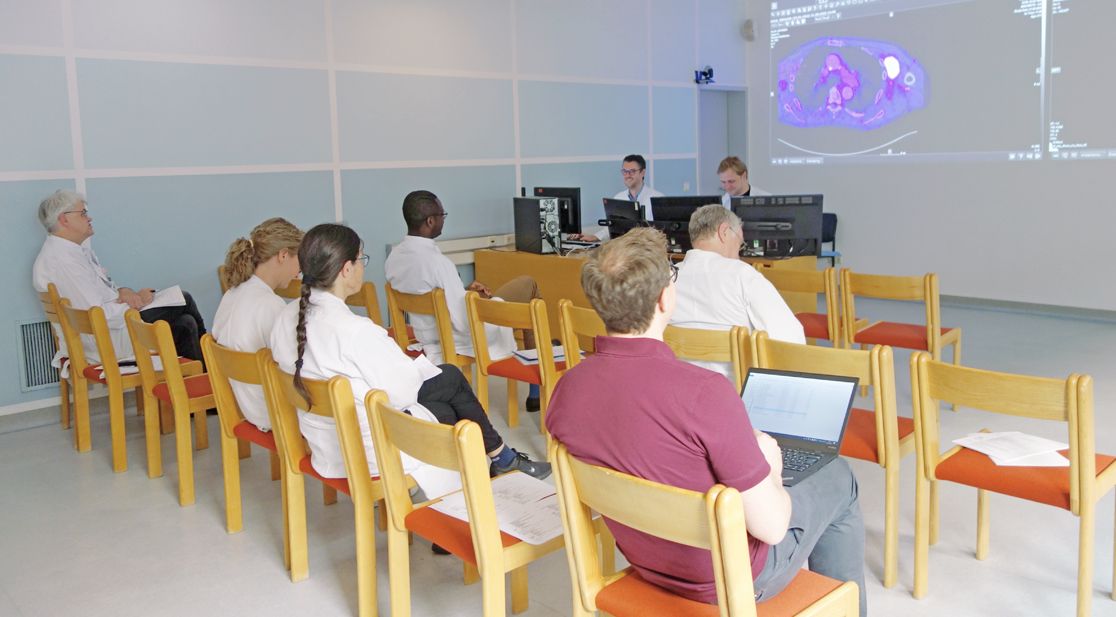 Schmuckbild: Ärzte sitzen beim Vortrag einer Tumorkonferenz