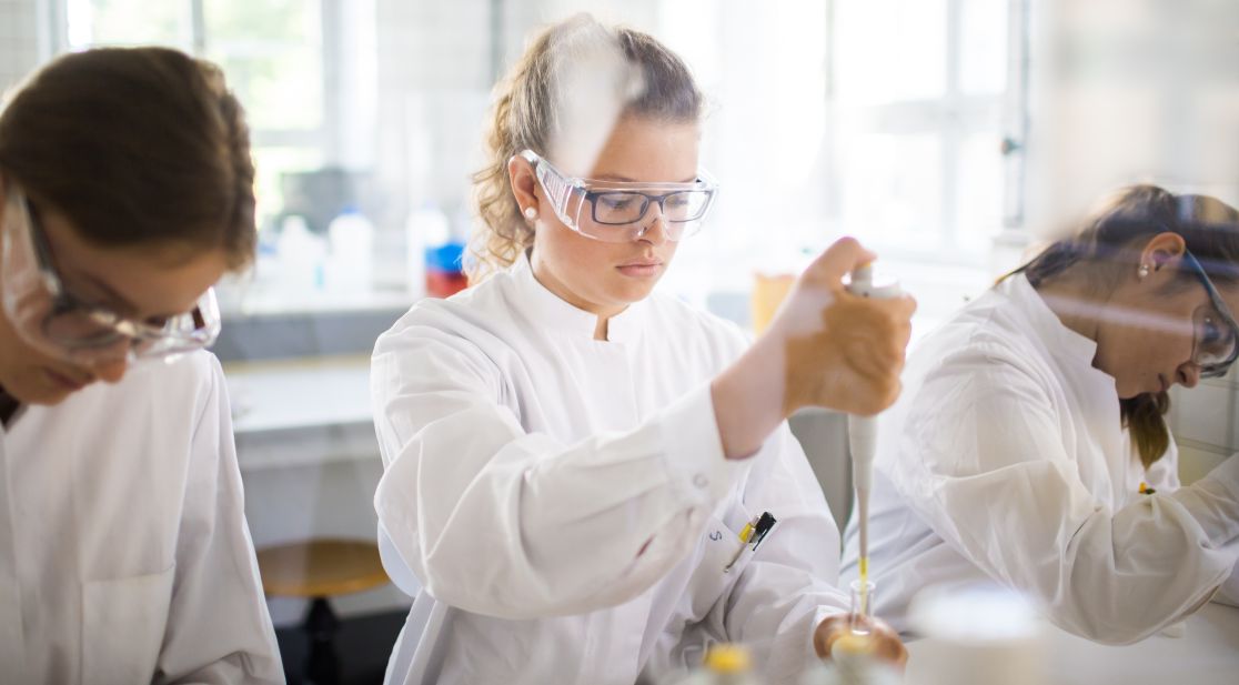 Drei Personen im Labor mit Pipette
