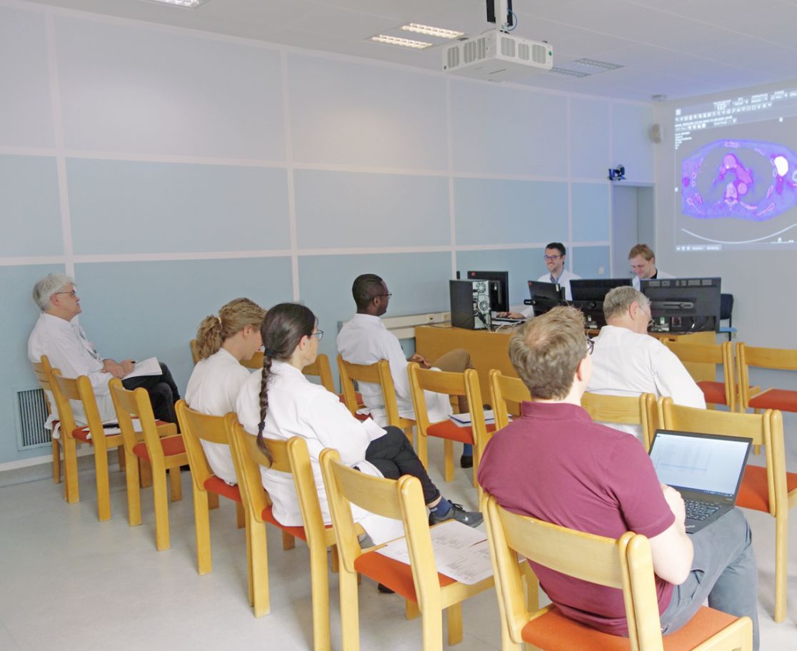 Schmuckbild: Ärzte sitzen beim Vortrag einer Tumorkonferenz