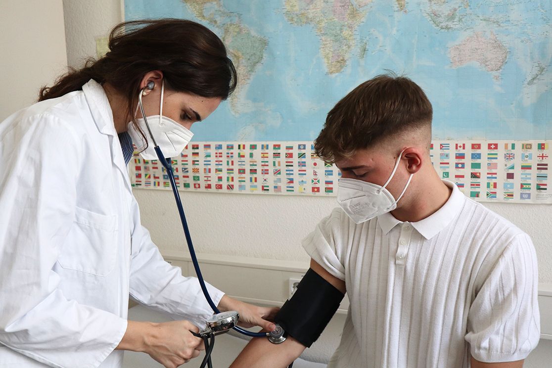 Ärztin misst Blutdruck bei jungem Patienten