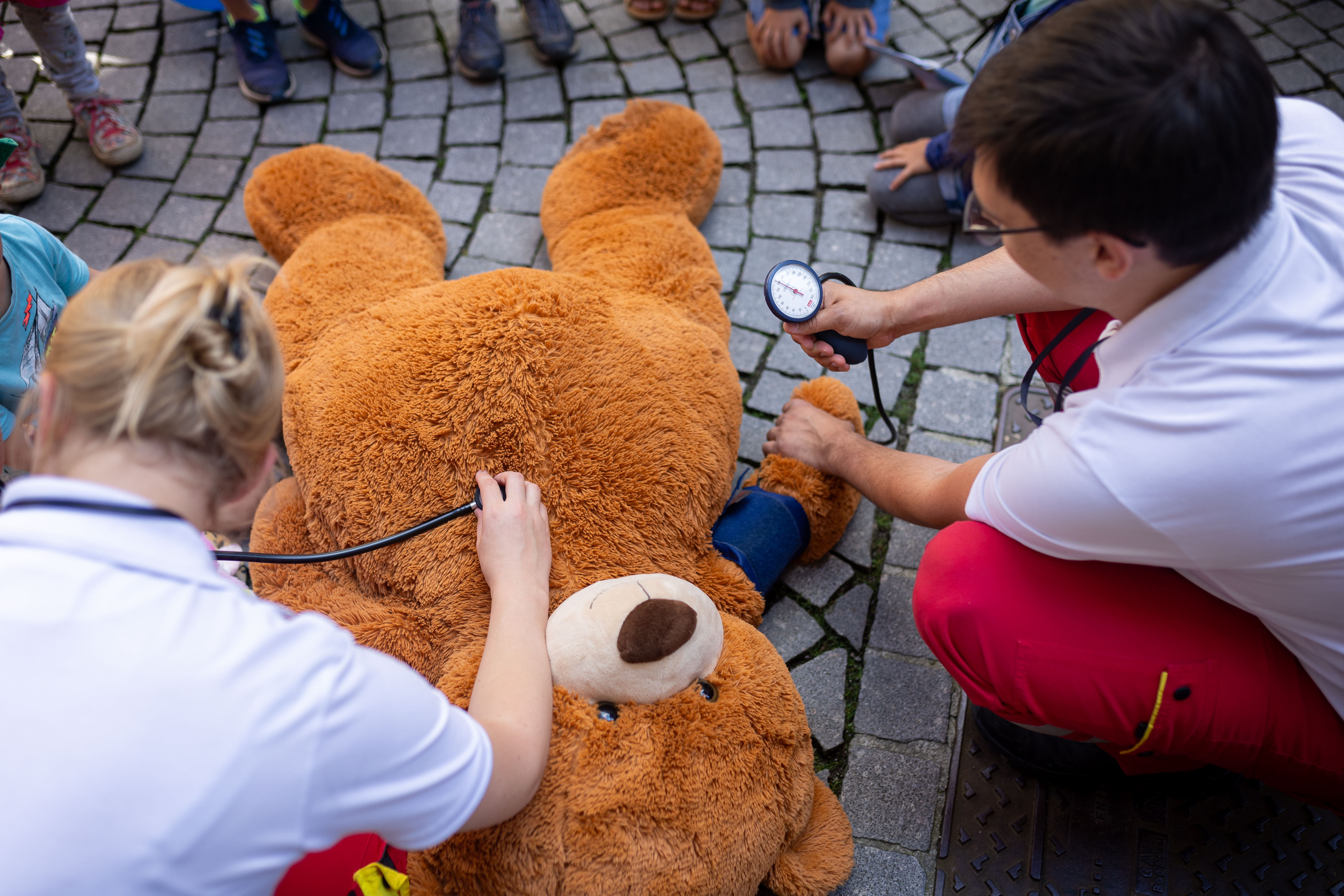Ein Team aus Rettungssanitätern versorgt einen großen braunen Teddybären.